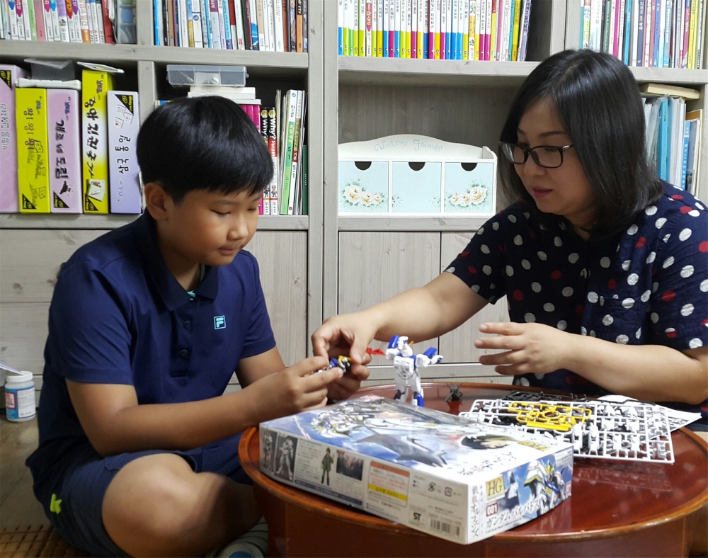 가족형포상제의 자기개발활동으로 프라모델 만들기를 하고 있는 윤지섭 군(오른쪽)과 어머니 김진아 씨.